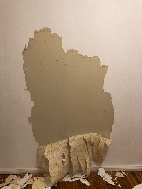 woodchip wallpaper half-peeled off a wall