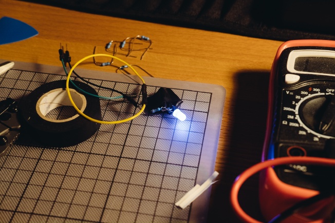 A small lump of electrical tape with a resistor and LED poking out of it