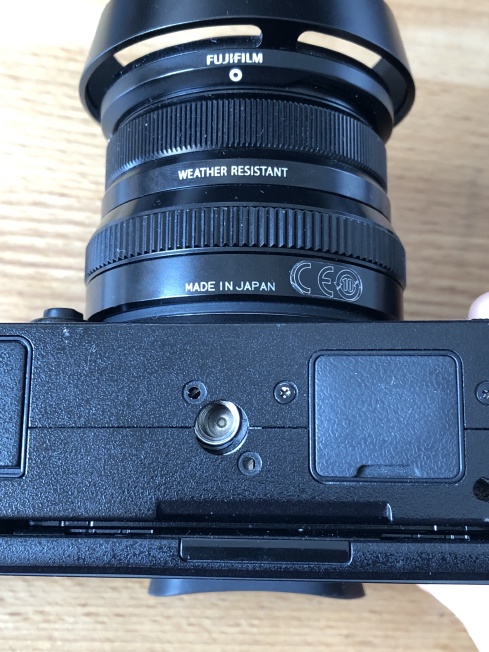 A photo of the underside of a Fuji X-T2, showing that the tripod mounting point has moved inside the case.