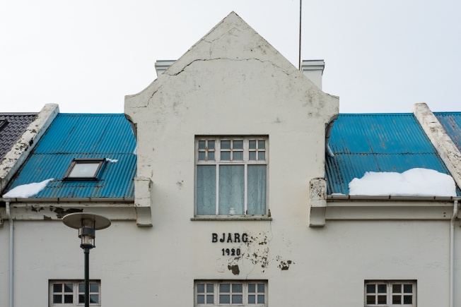 A more ornate house with a sky-blue corrugated steel roof. It says Bjarg 1920 on the front.