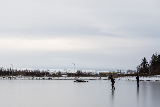 people ice-skating on a frozen lake