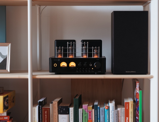 A photo of an HTA100 hybrid / tube amplifier on a bookshelf